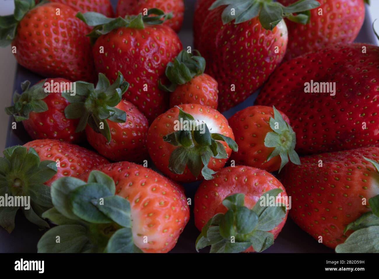 Strawberries on gray ceramic plate. vertical plane Stock Photo