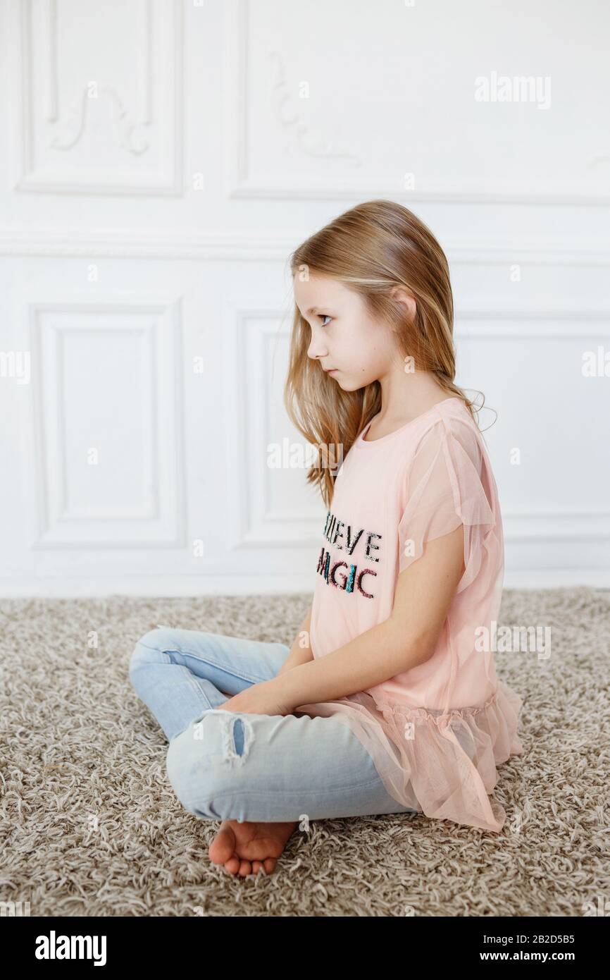 Cute pre-teen girl wearing fashion clothes posing in white interior. little  but very serious girl Stock Photo - Alamy