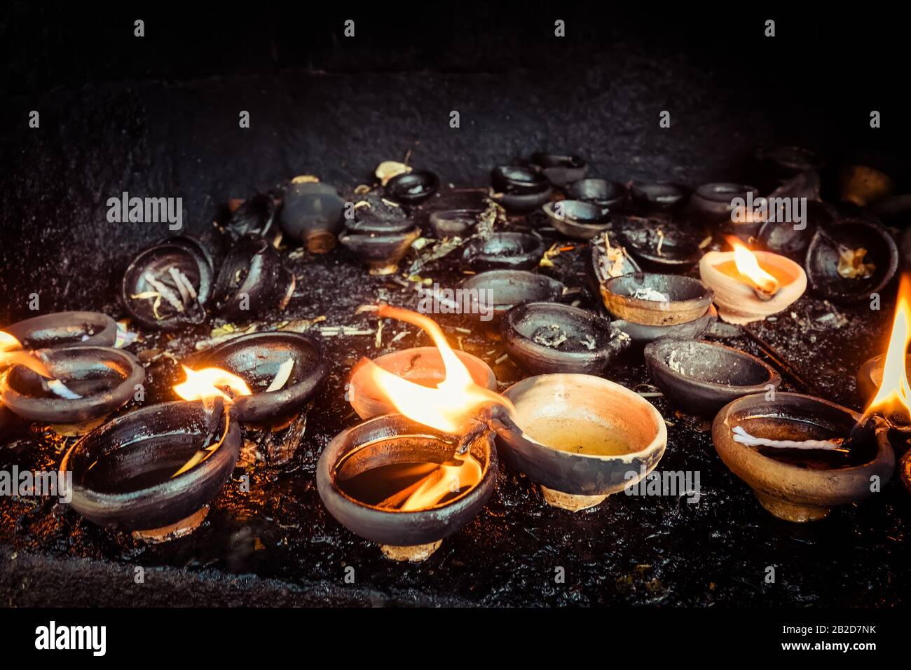 Burning oil lamps at temple. Traditional offering in buddhist and hindu temple Stock Photo