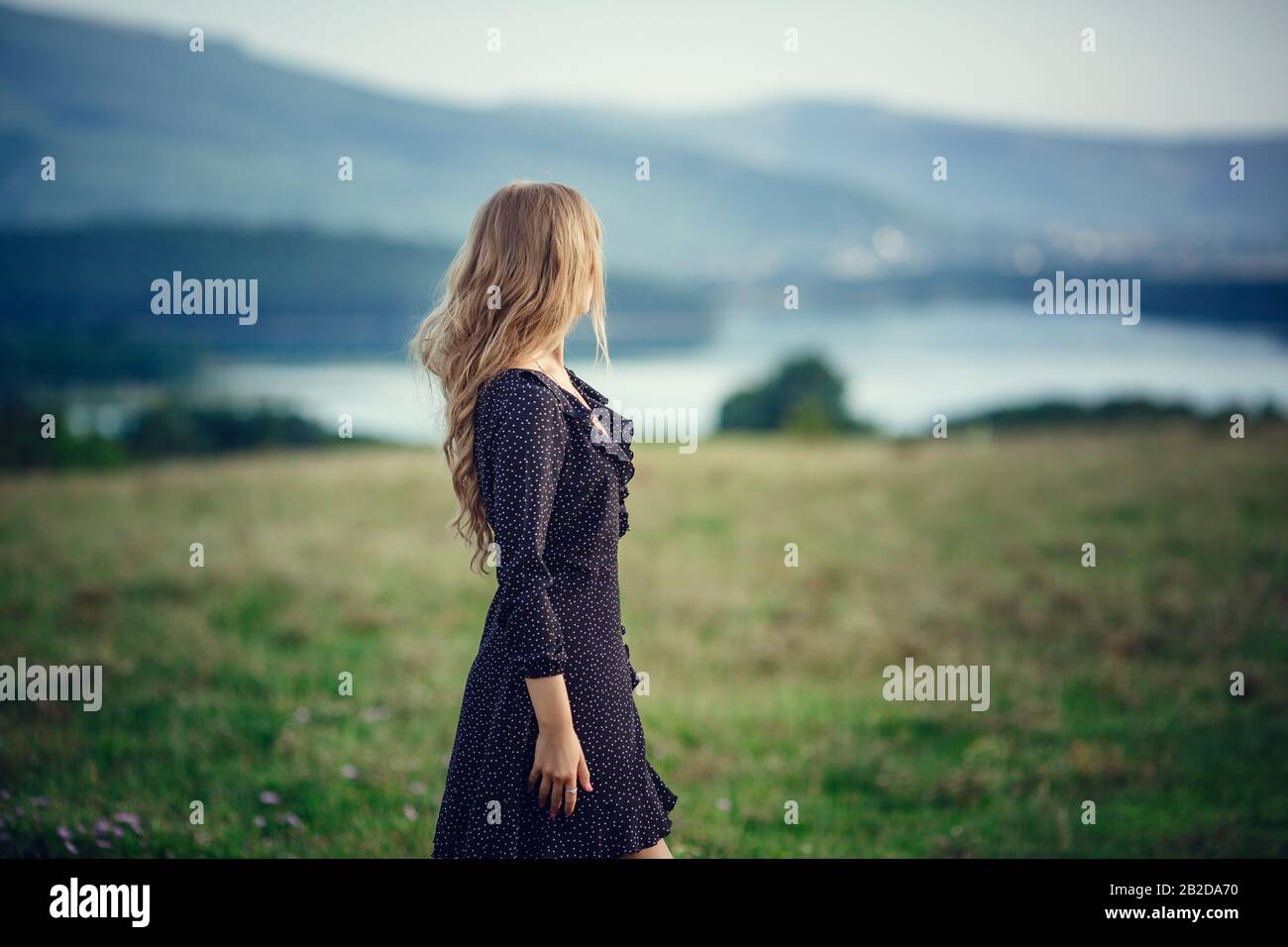 Happy pretty girl in field at sunset. Art photo. Forest and lake. The ...