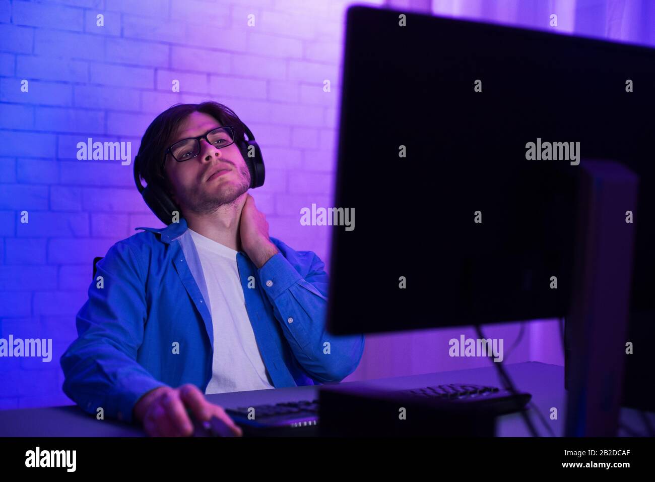 Tired Programmer Working On Computer Touching Aching Neck At Home Stock Photo