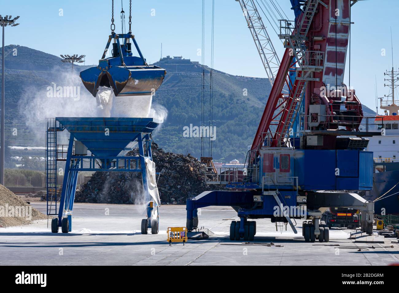 Crane in the port unloading a ship carrying fertilizer Stock Photo