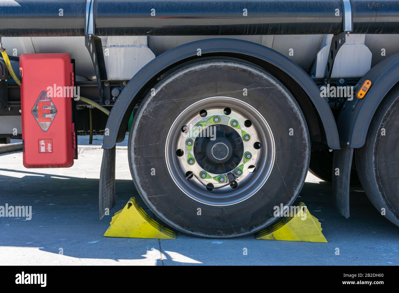 Tanker truck wheel with chocks placed for safety Stock Photo