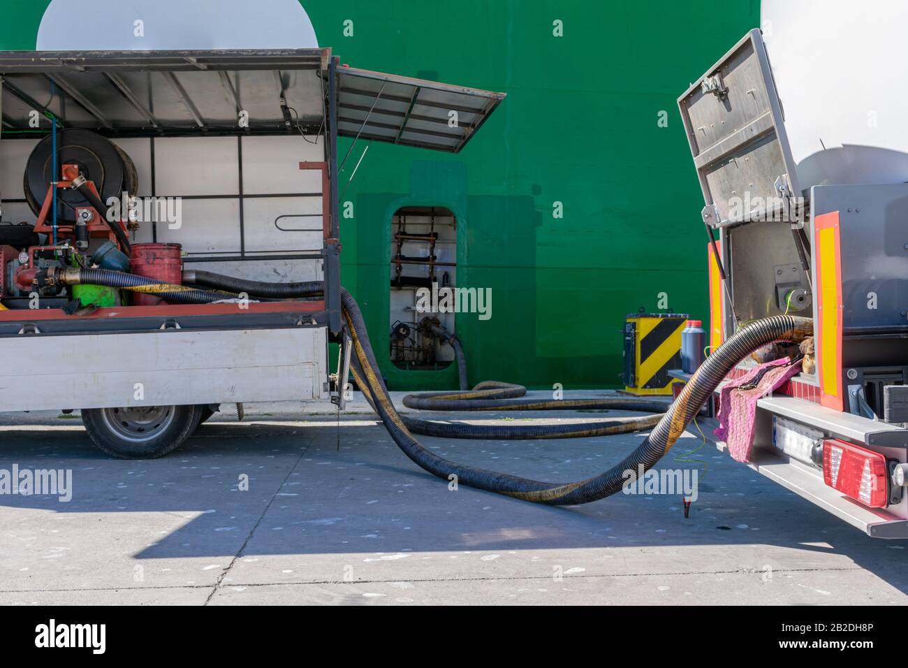 Hoses connected to a ship in the port for fuel supply Stock Photo