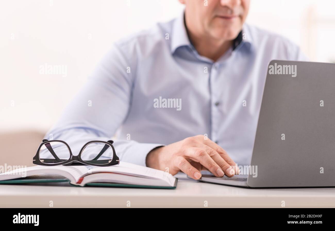 Unrecognizable mature man using laptop at office Stock Photo