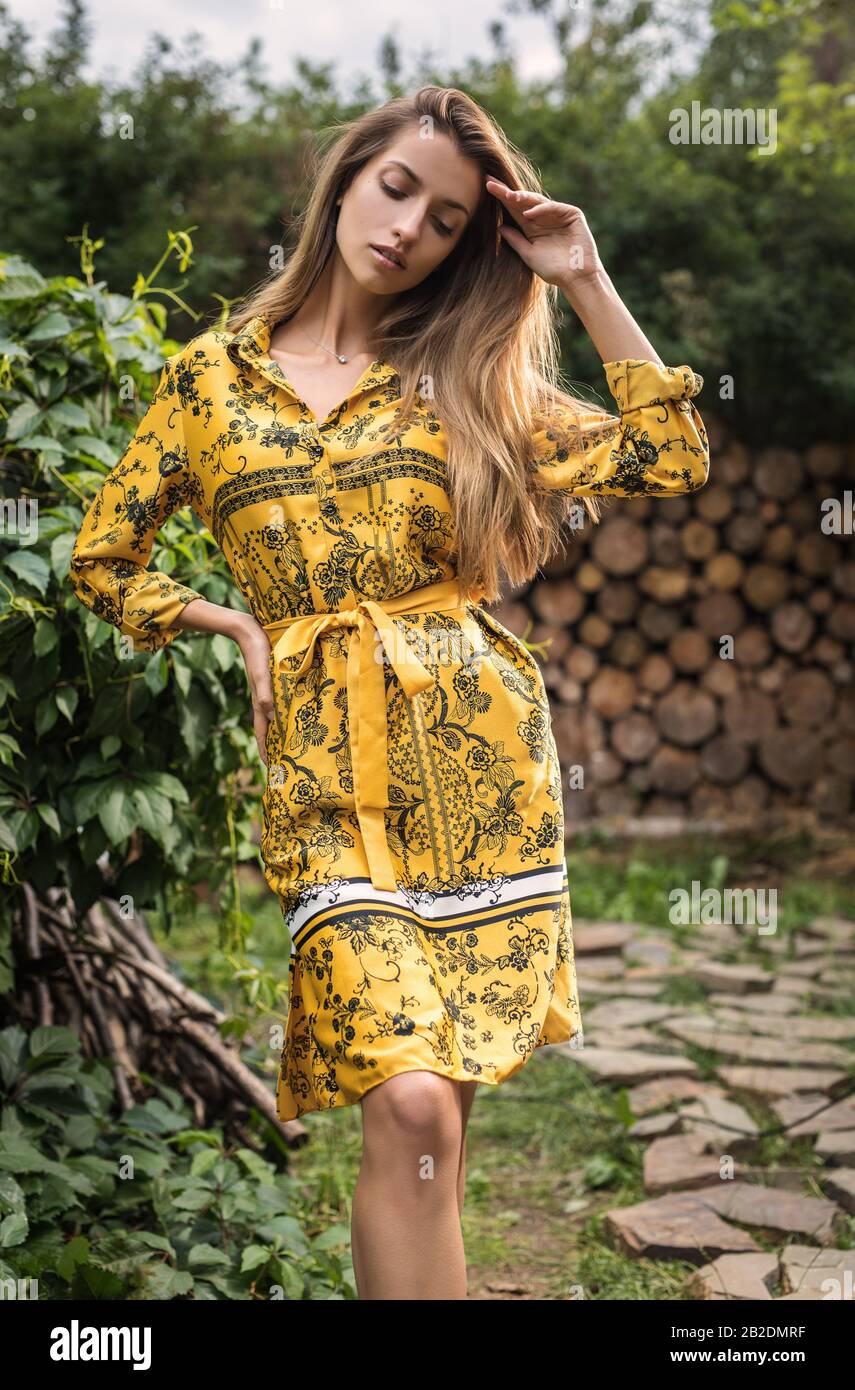 Beautiful emotional outdoor portrait of young woman in yellow dress ...