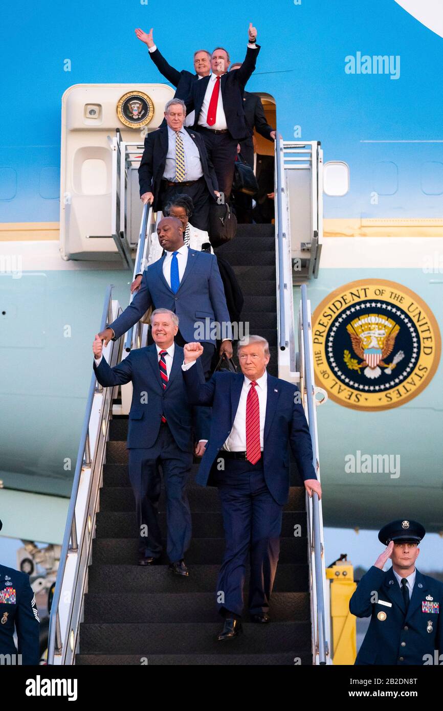 U.S President Donald Trump waves to supporters as he disembarks Air Force One accompanied by Senators Lindsey Graham and Tim Scott at Charleston International Airport February 28, 2020 in Charleston, S.C. Trump arrived Charleston to hold a campaign rally on the eve of the Democratic primary in the state. Stock Photo