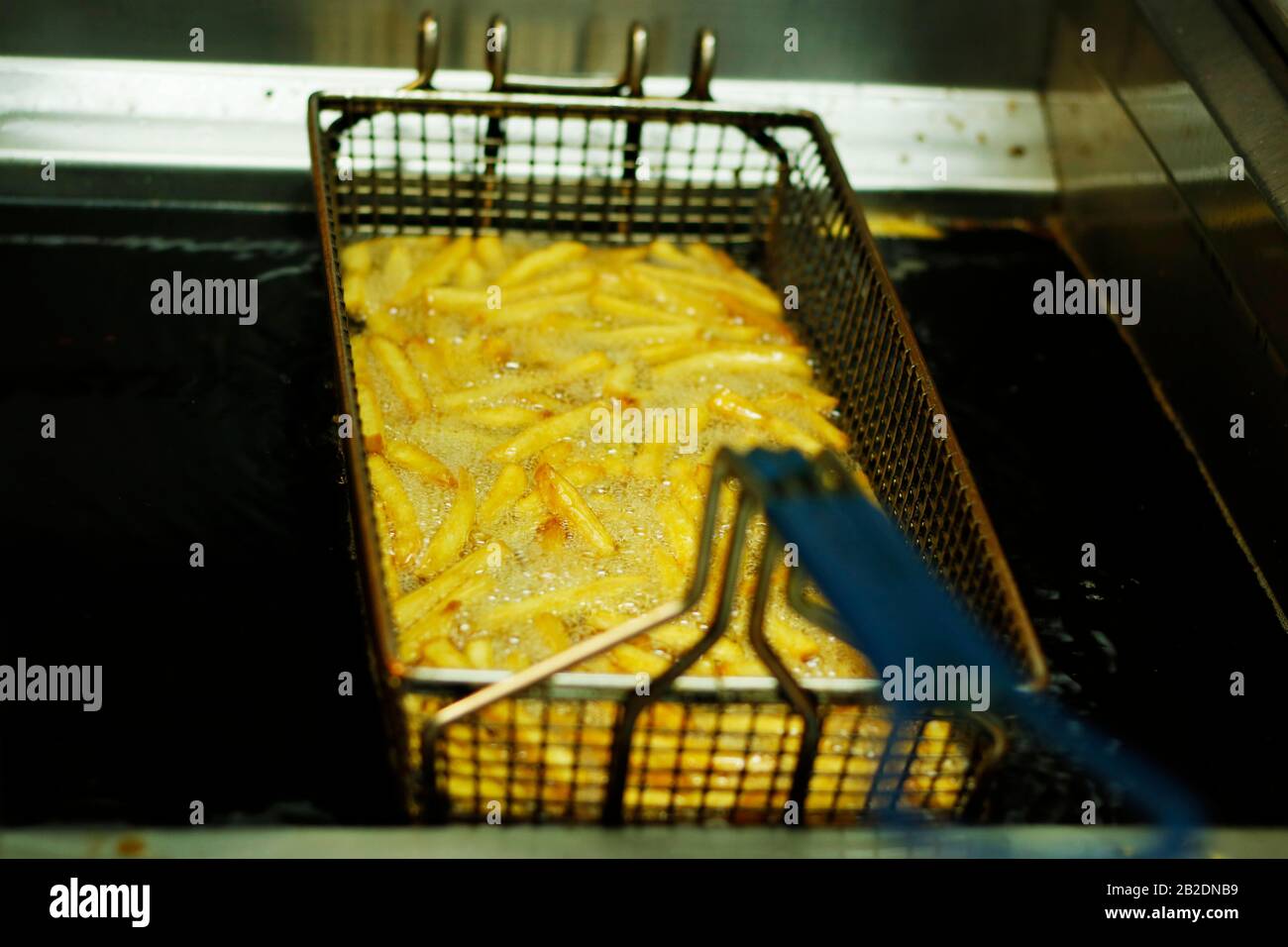 potato chips frying in a deep fat fryer Stock Photo Alamy
