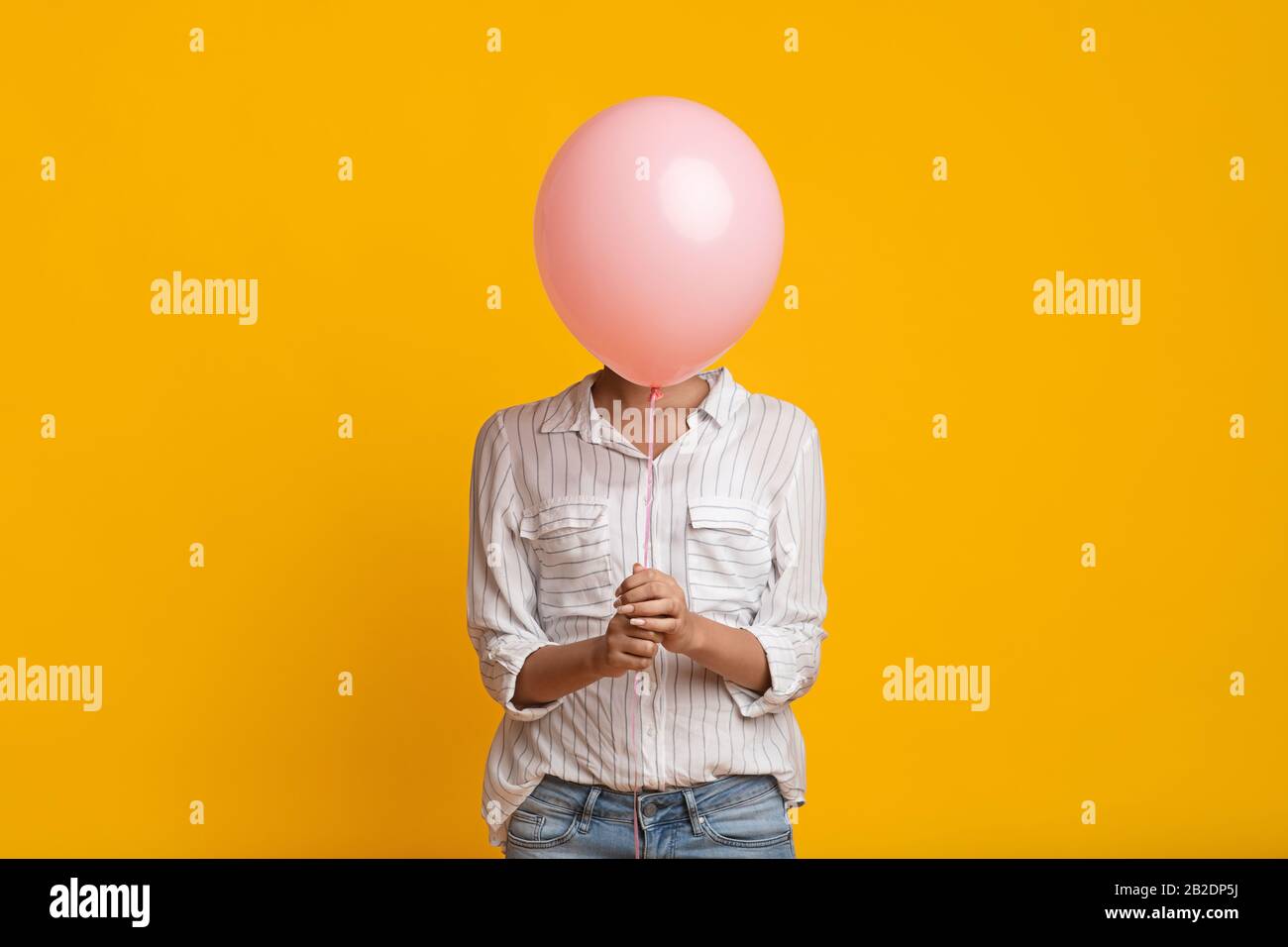 Unrecognizable Black Girl Hiding Face Behind Pink Balloon Stock Photo