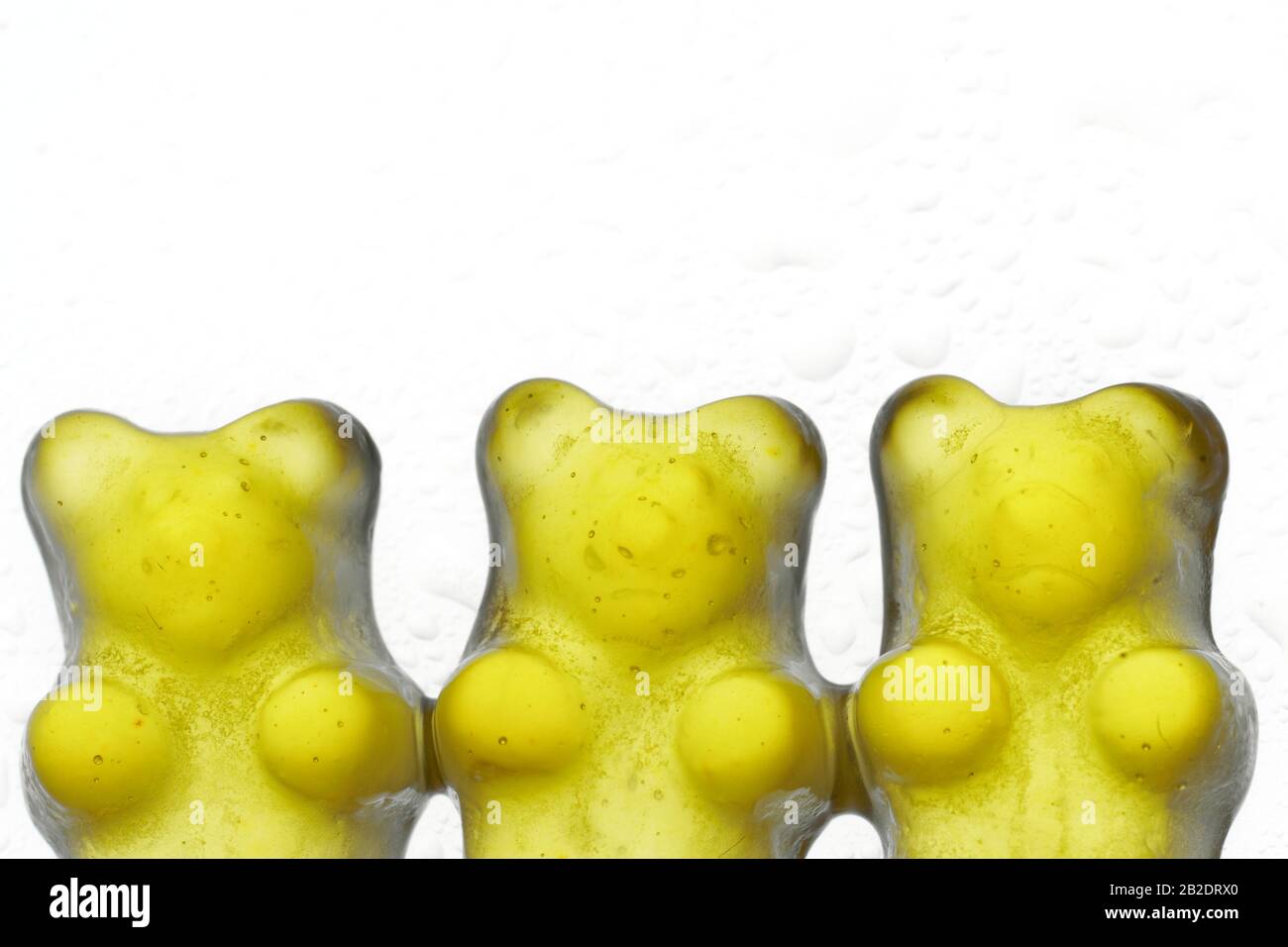 Yellow jelly bear candy aligned on a white background Stock Photo