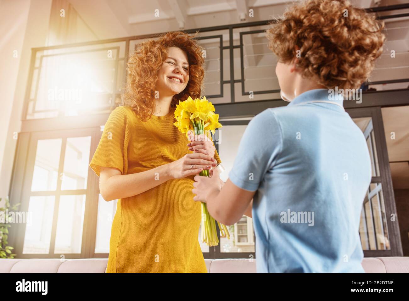 Mum receive flower as present from her son. Concept of mother day Stock Photo