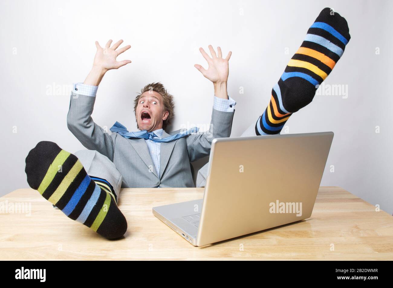 Screaming businessman falling back from his desk with his eyes still