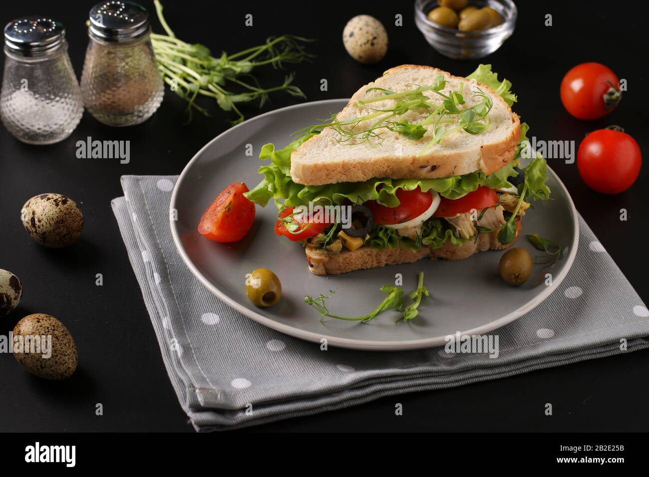 Sandwich with chicken, cherry tomatoes, quail eggs and microgreens