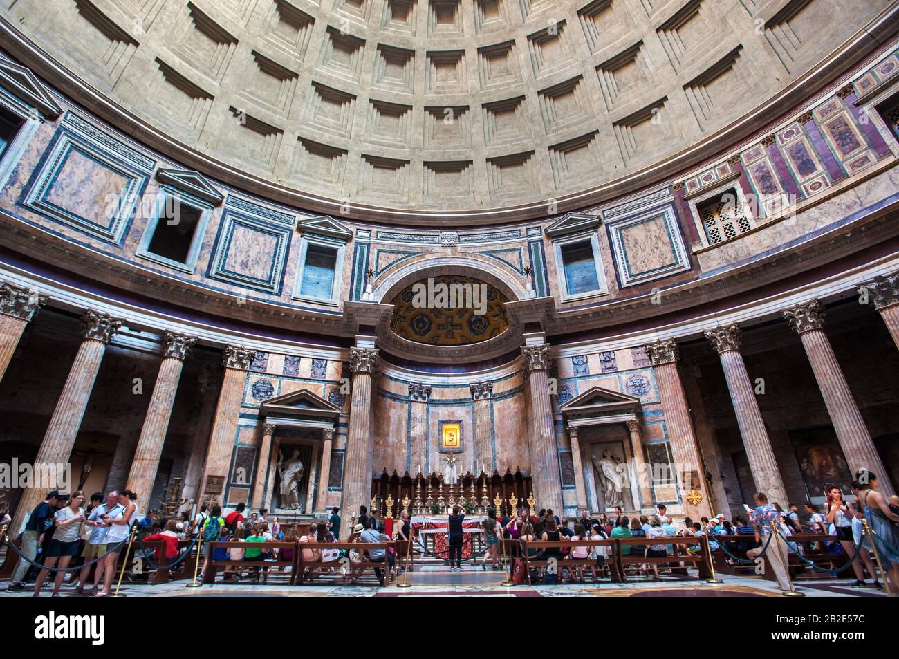 Tourists admire the altar and famous domed ceiling inside the Pantheon building in Rome Stock Photo