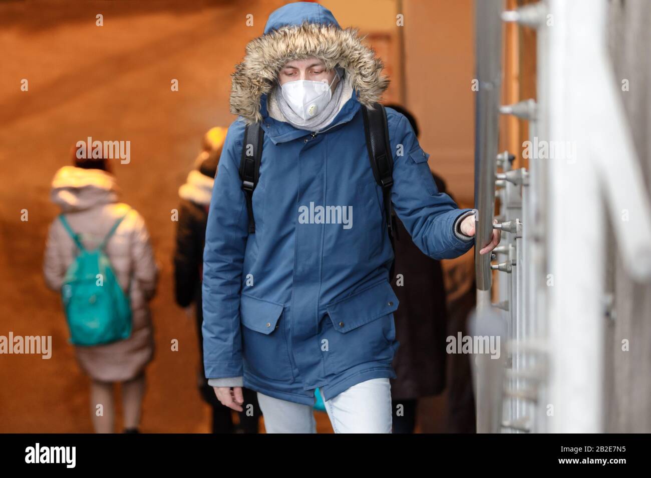 Sick man with a hood wearing protective facial mask against transmissible infectious diseases and as protection against the flu or coronavirus in publ Stock Photo