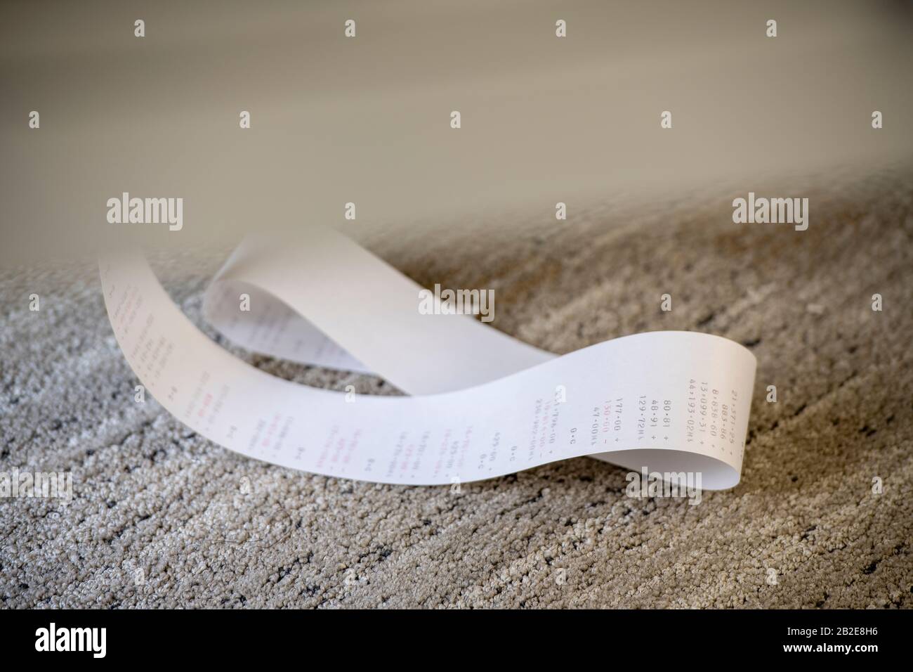 Adding Machine paper tape gathered on carpeted floor Stock Photo