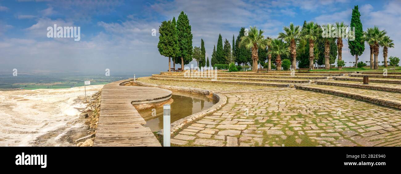 A path in a small park with a viewing platform on top of the white Pamukkale mountain near travertines on a summer morning. Stock Photo