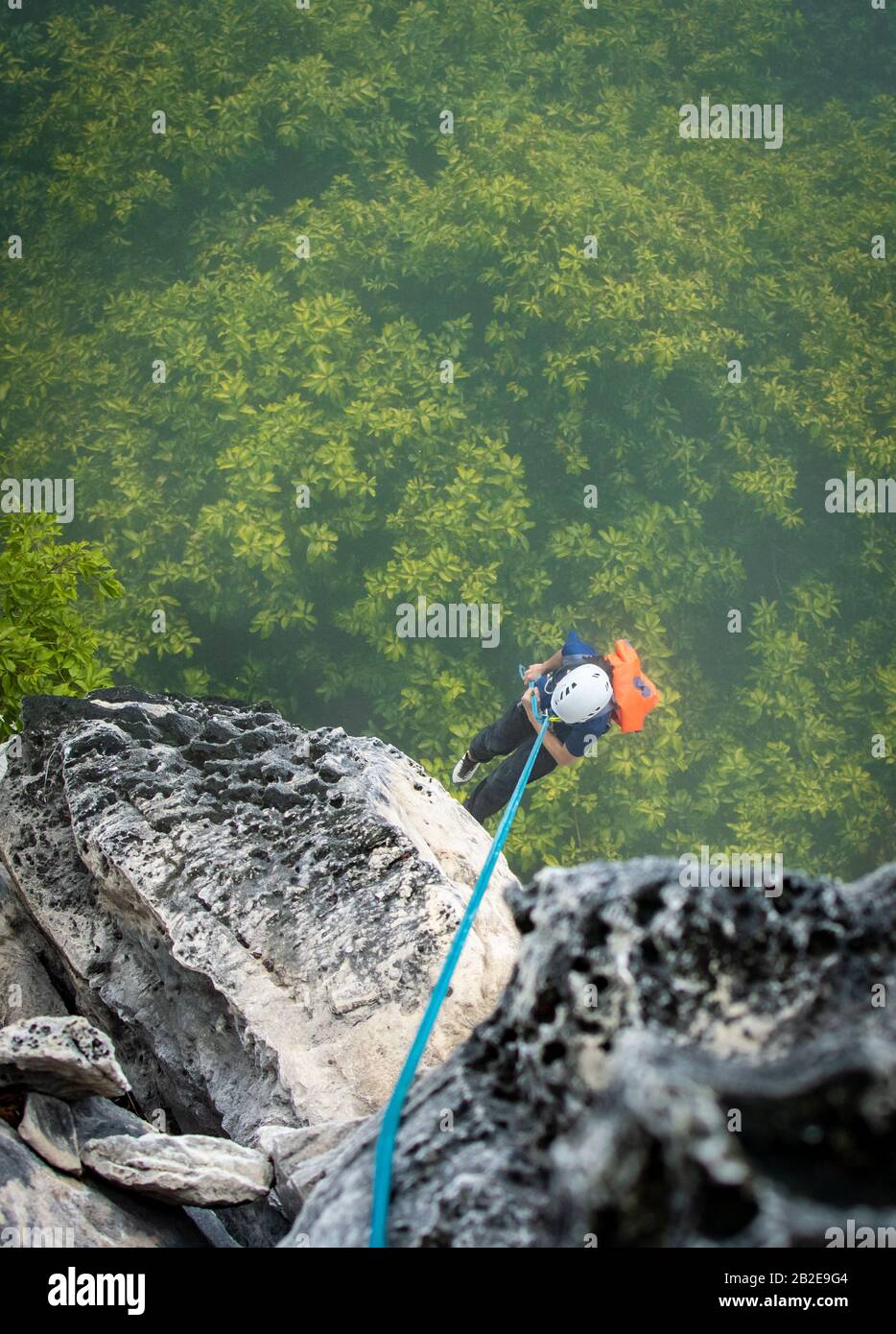 climbing abseil off rock wall Stock Photo
