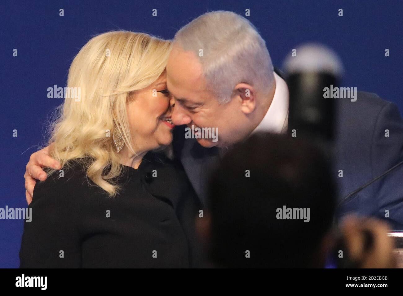 Tel Aviv, Israel. 03rd Mar, 2020. Israeli Prime Minister and Chairman of the Likud Party, Benjamin Netanyahu, embraces his wife Sara as he addresses supporters following early exit polls. Credit: Ilia Yefimovich/dpa/Alamy Live News Stock Photo