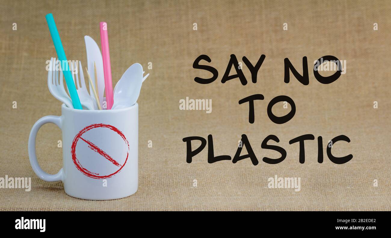 Say No to Plastic text next to single use plastic items in mug, refuse single use plastic cutlery and straws. Stock Photo