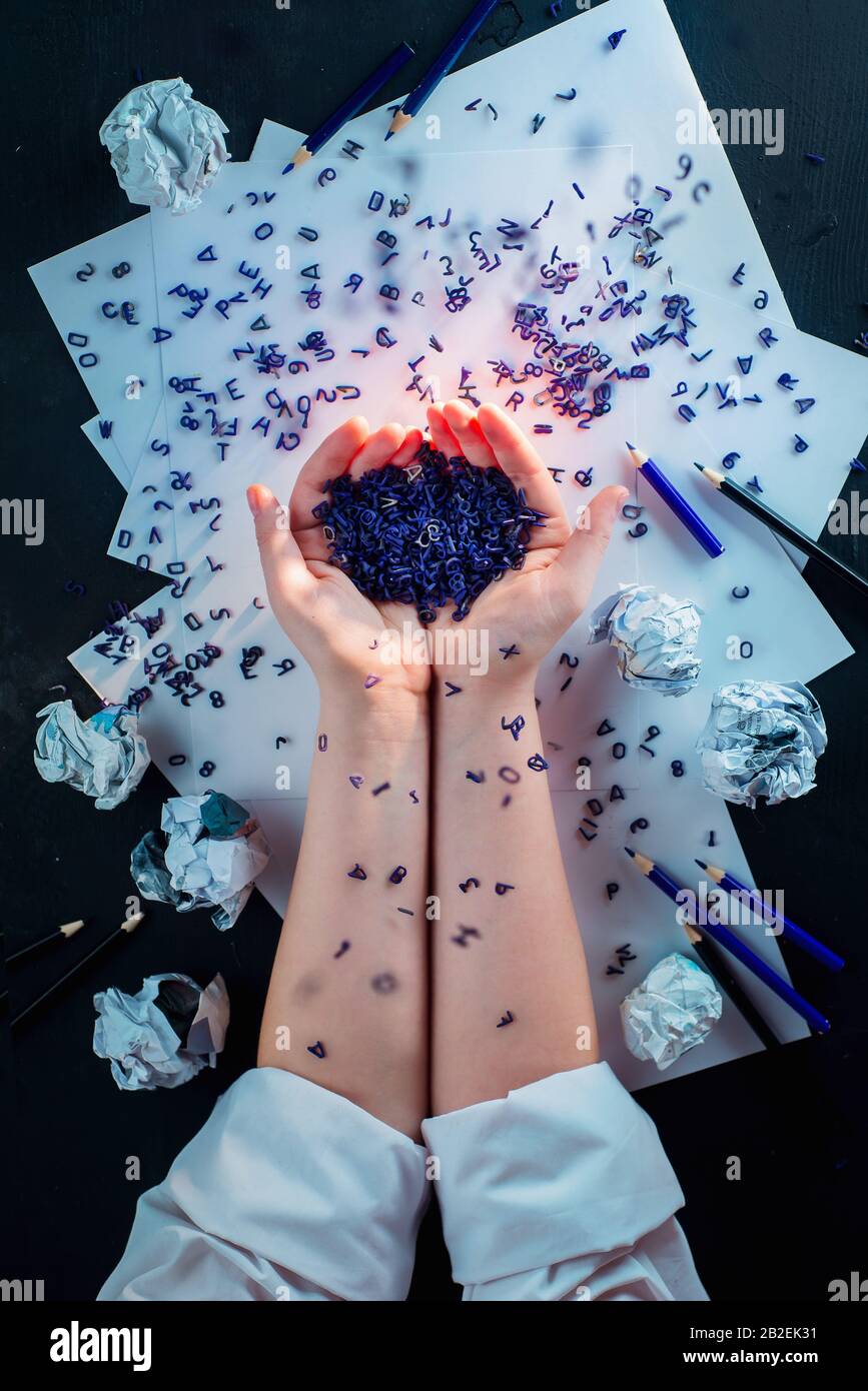 Spilled letters in hands of a writer, flat lay with hands, creative workplace Stock Photo