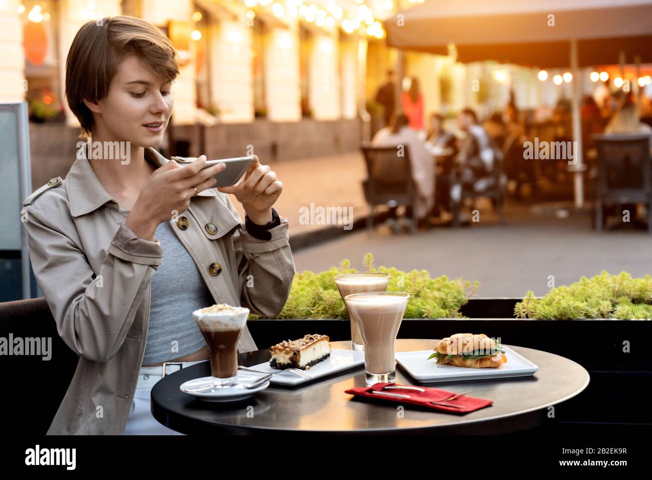 Pretty young blogger cafe table post food photo instagram feed copy spac. Stock Photo