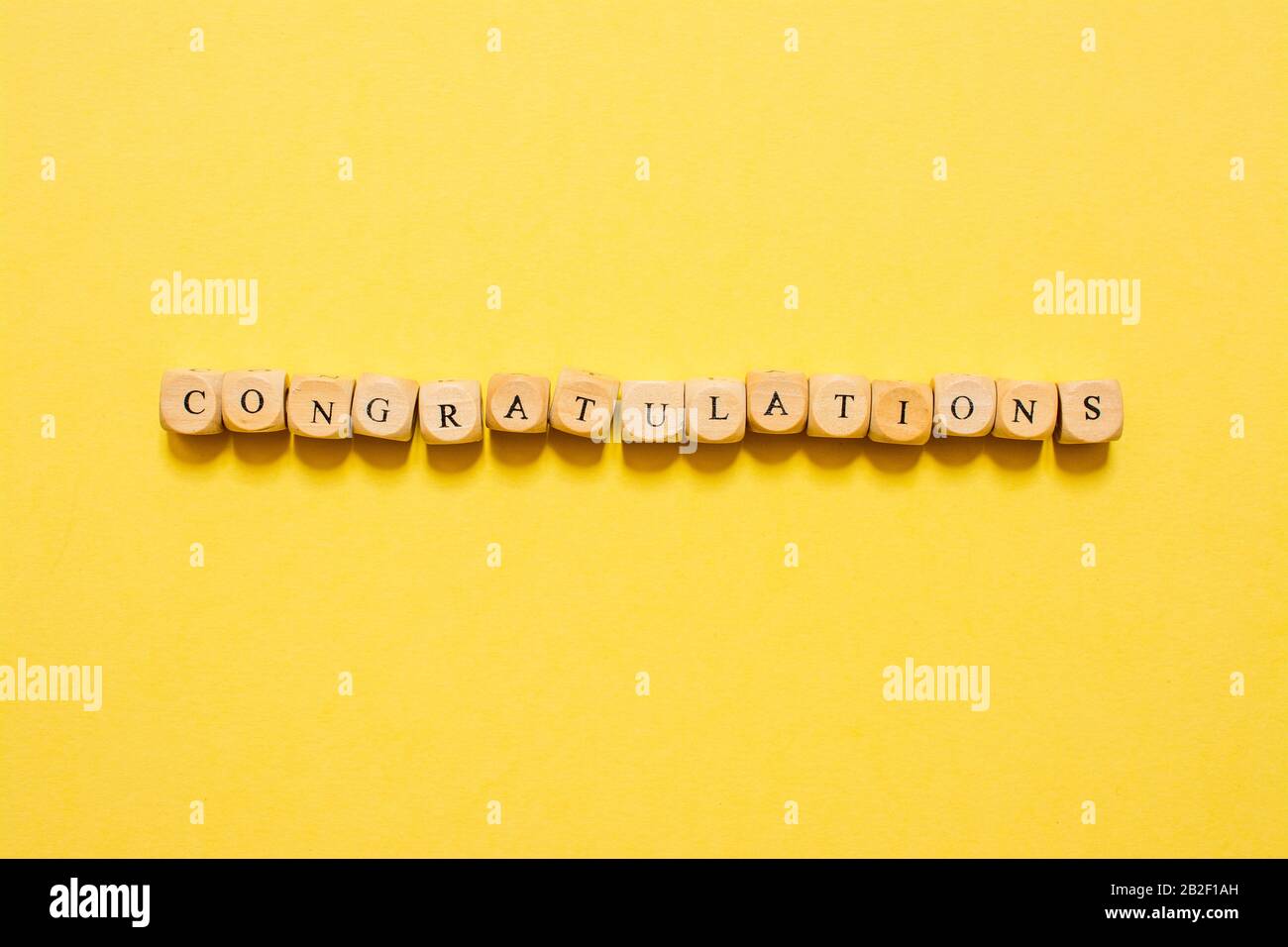 the word Congratulations, text made with dice on yellow background Stock Photo