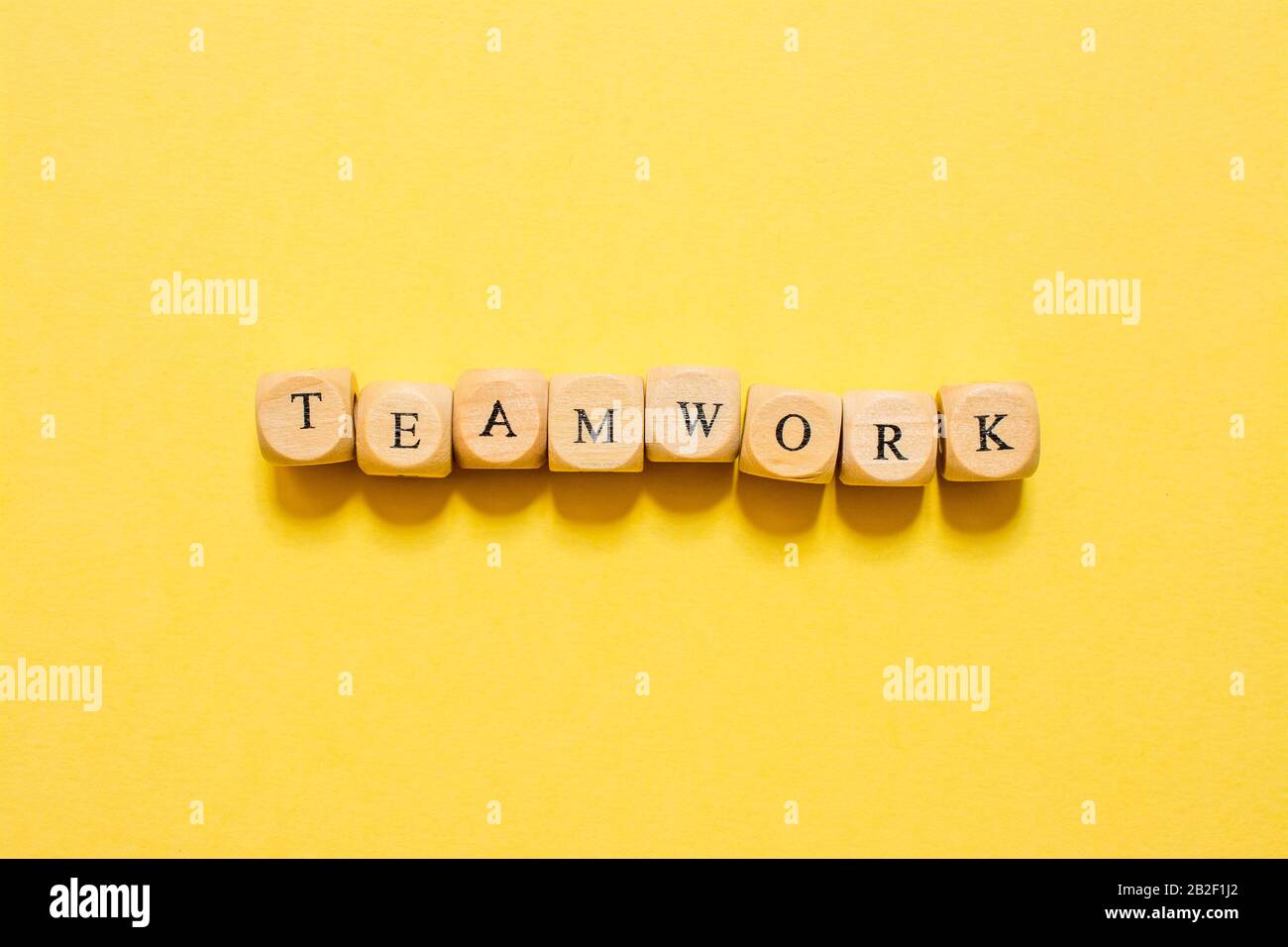the word Teamwork, text made with dice on yellow background Stock Photo ...