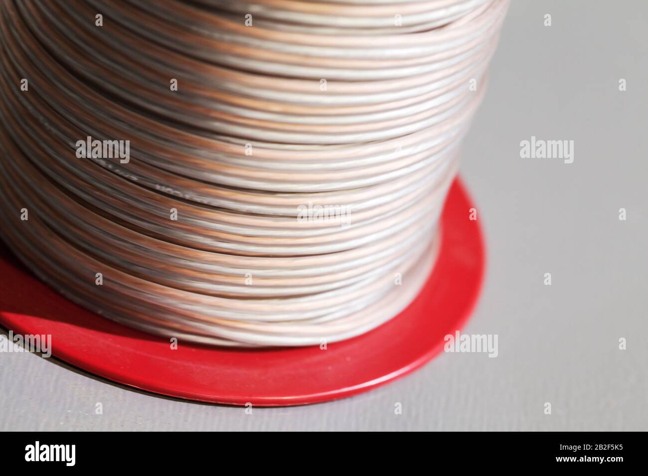 Cable reel with speaker wire close up photo. It is used to make the electrical connection between loudspeakers and audio amplifiers Stock Photo