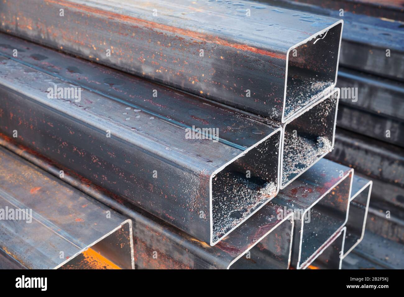 Stacked rolled metal products, wet steel pipes of rectangular cross-section Stock Photo