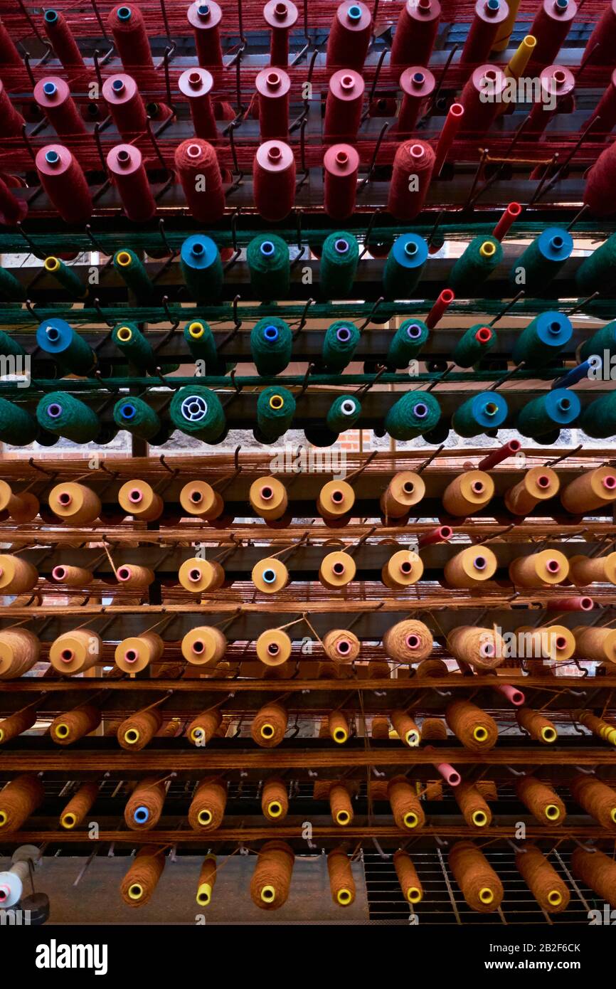 Rows of thread on spools are ready to supply a weaving loom. At the National Wool Museum in