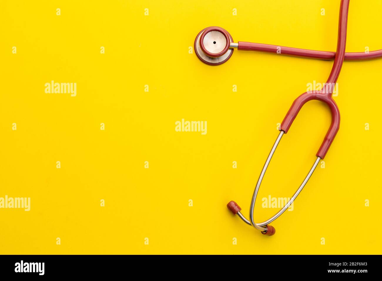 Top view red stethoscope on yellow background. For check heart or health check up concept Stock Photo