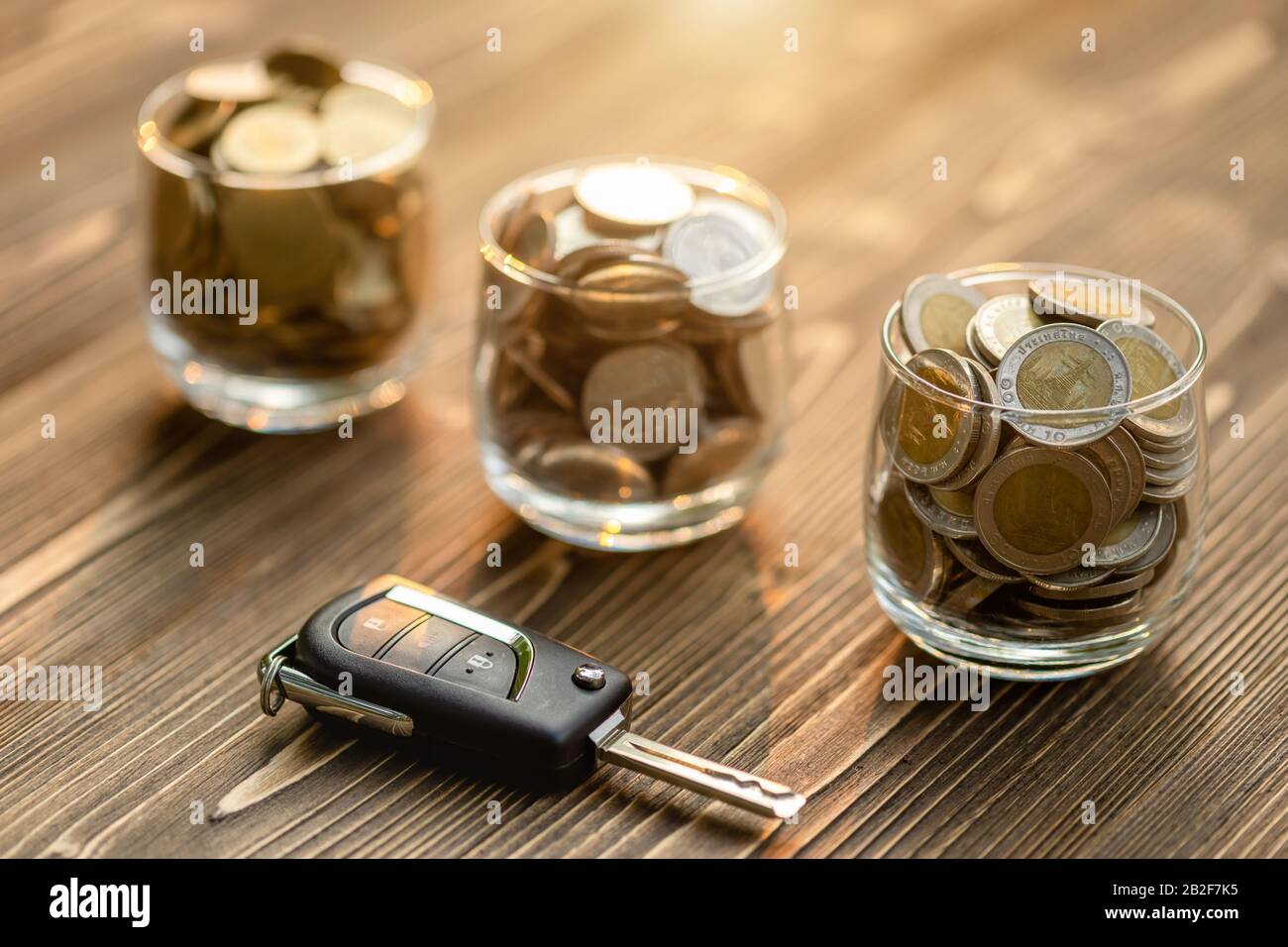 Close up new car keys pile of coin on wooden table. Car financial, Car purchase, or car rental concept Stock Photo