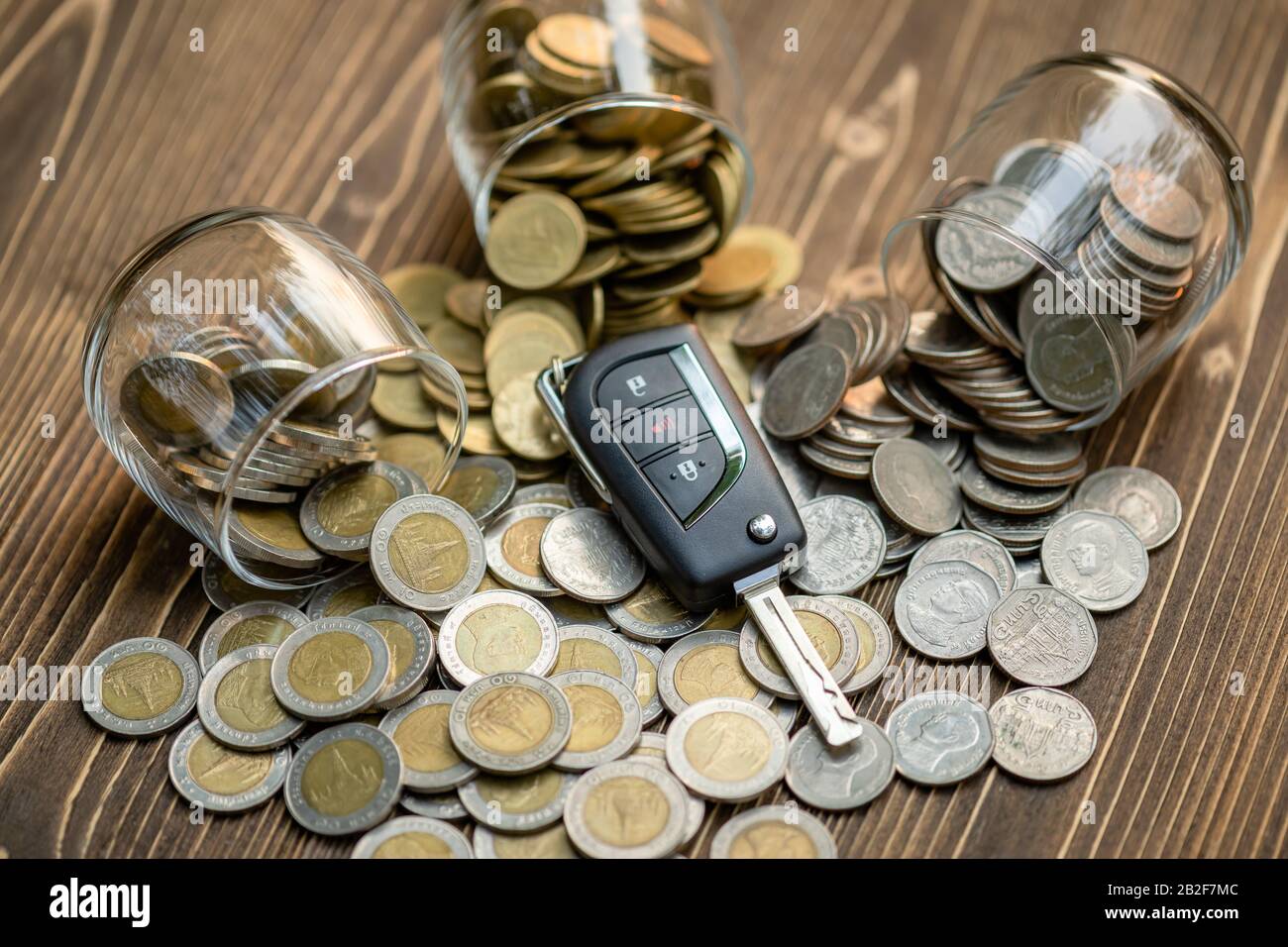 Close up new car keys pile of coin on wooden table. Car financial, Car purchase, or car rental concept Stock Photo