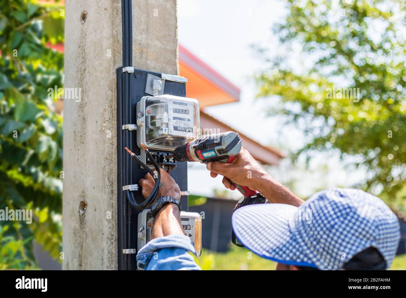 Technician installing electric meter on the pole to measurement watt in