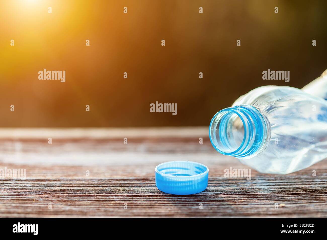 Heap of empty clear plastic water bottle on wooden plank. Close up