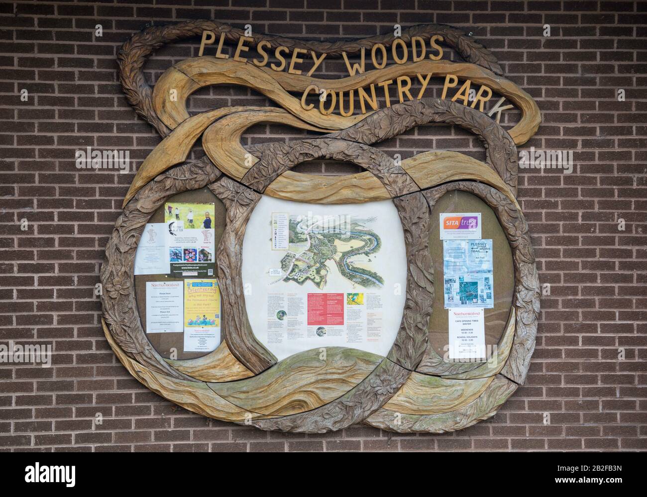 notice board with carved wooden surround on the wall of the visitor centre at Plessey Woods Country park near Bedlington, Northumberland Stock Photo