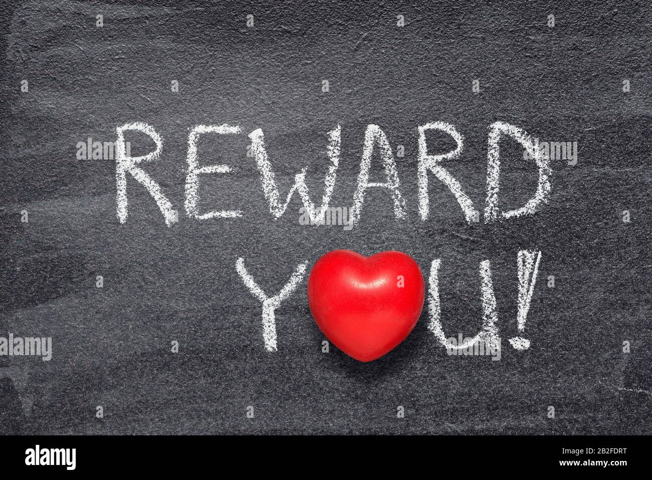 reward you exclamation written on chalkboard with red heart symbol Stock Photo
