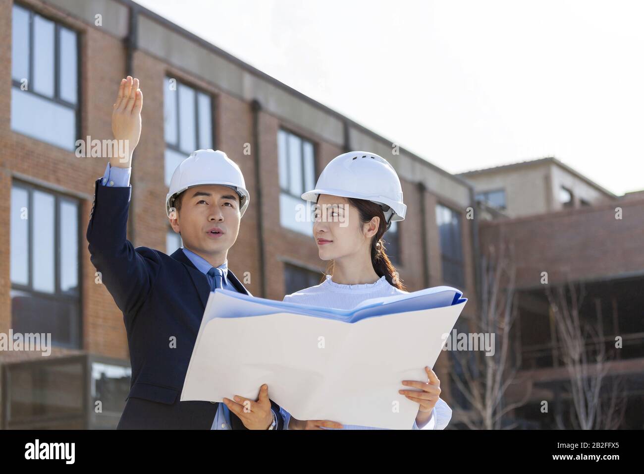 Two architects talking over blueprints Beijing China Stock Photo