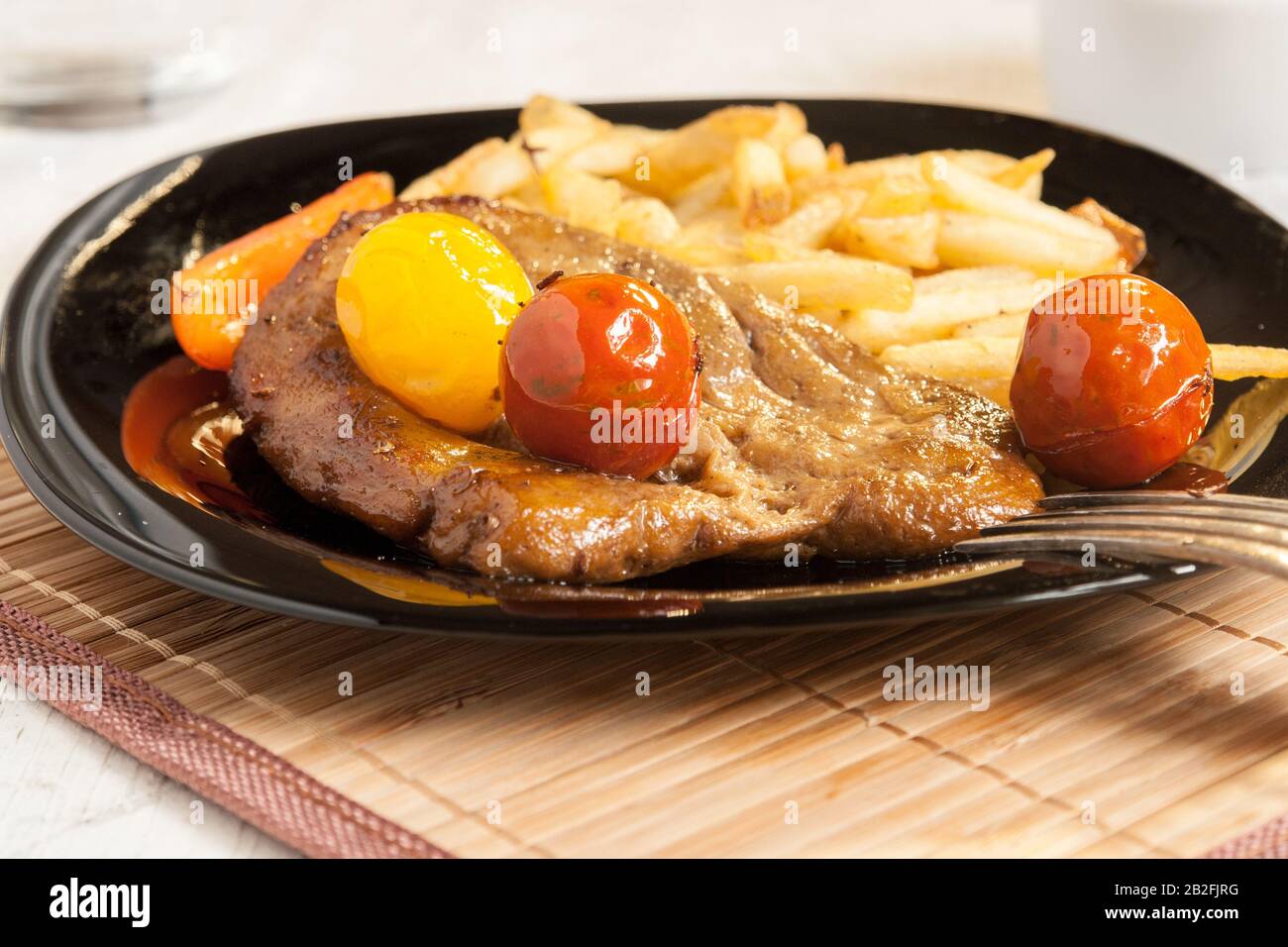 Vegetarian steak made from vegan meat seitan, with cherry tomatoes