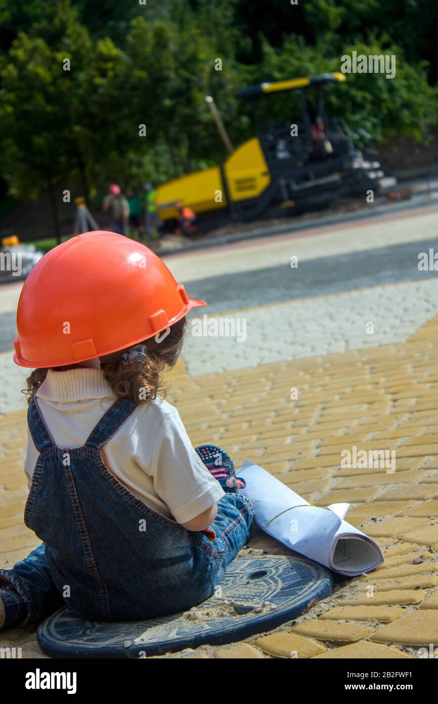 Little Baby Girl Builder With The Construction Helmet And Poster In Denim Uniform Smiling On Construction Site Stock Photo Alamy