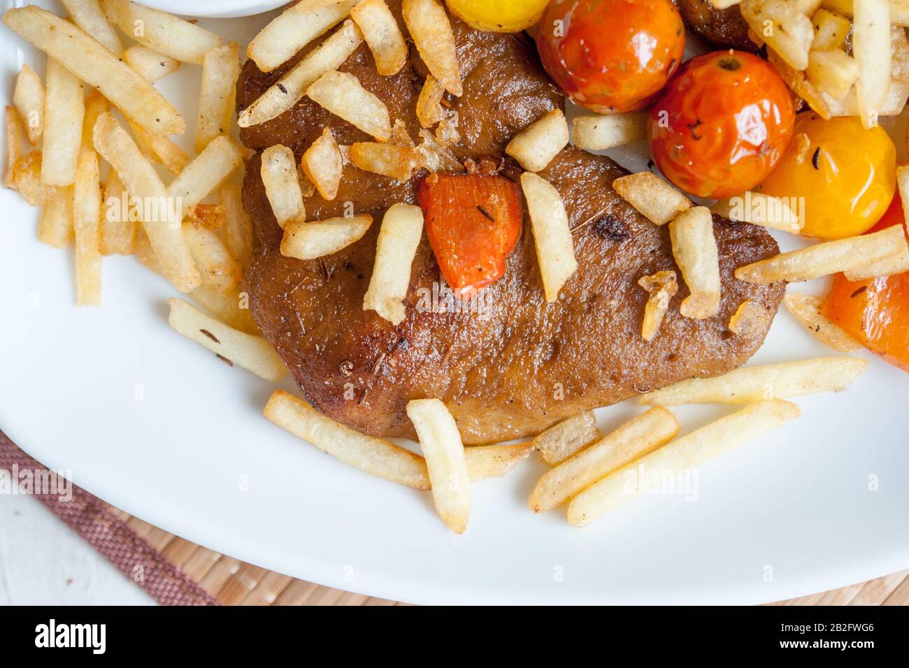 Vegetarian steak made from vegan meat seitan, with cherry tomatoes