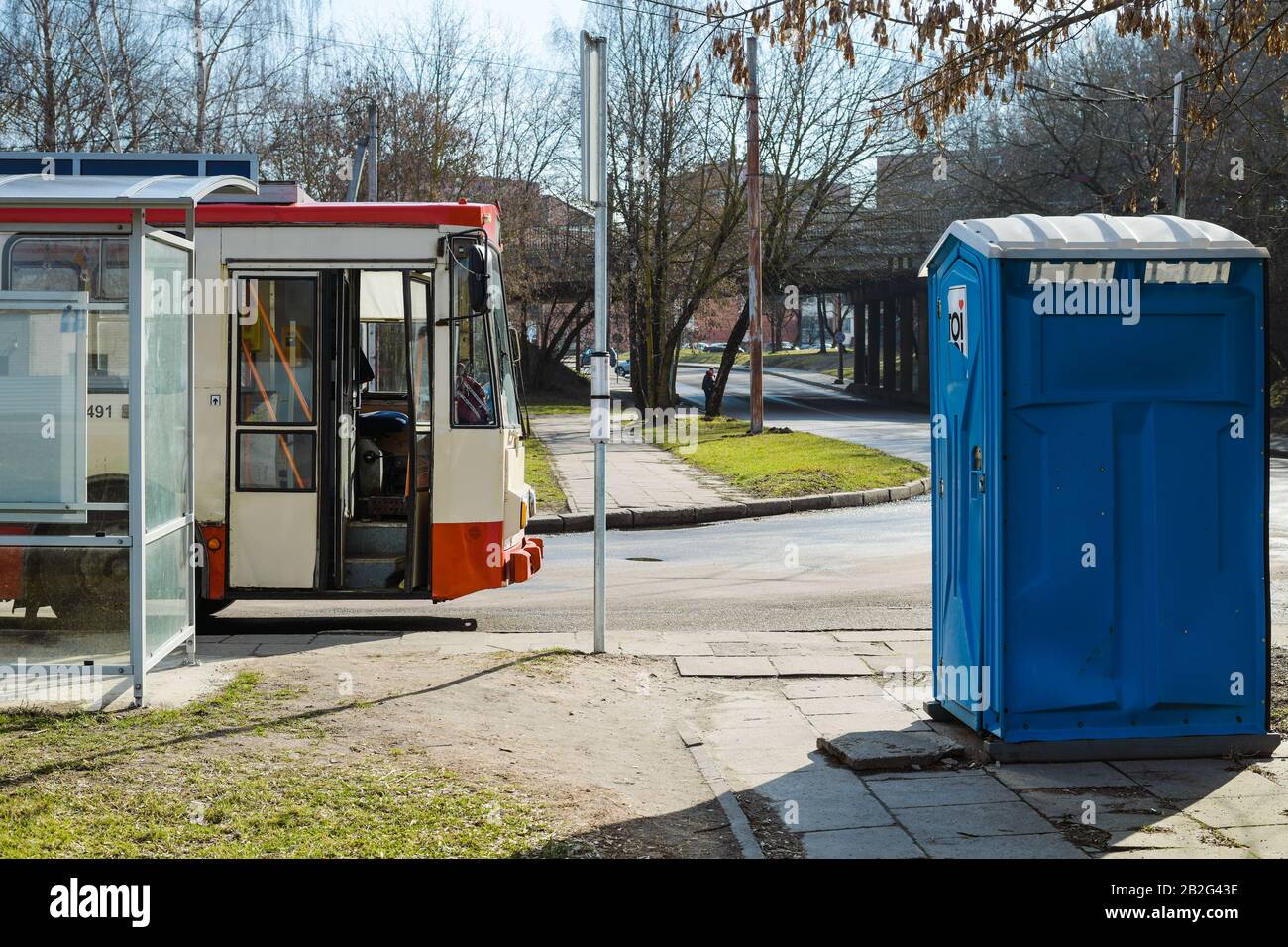 A trolleybus parked nearby public transport station next to public toilet Stock Photo