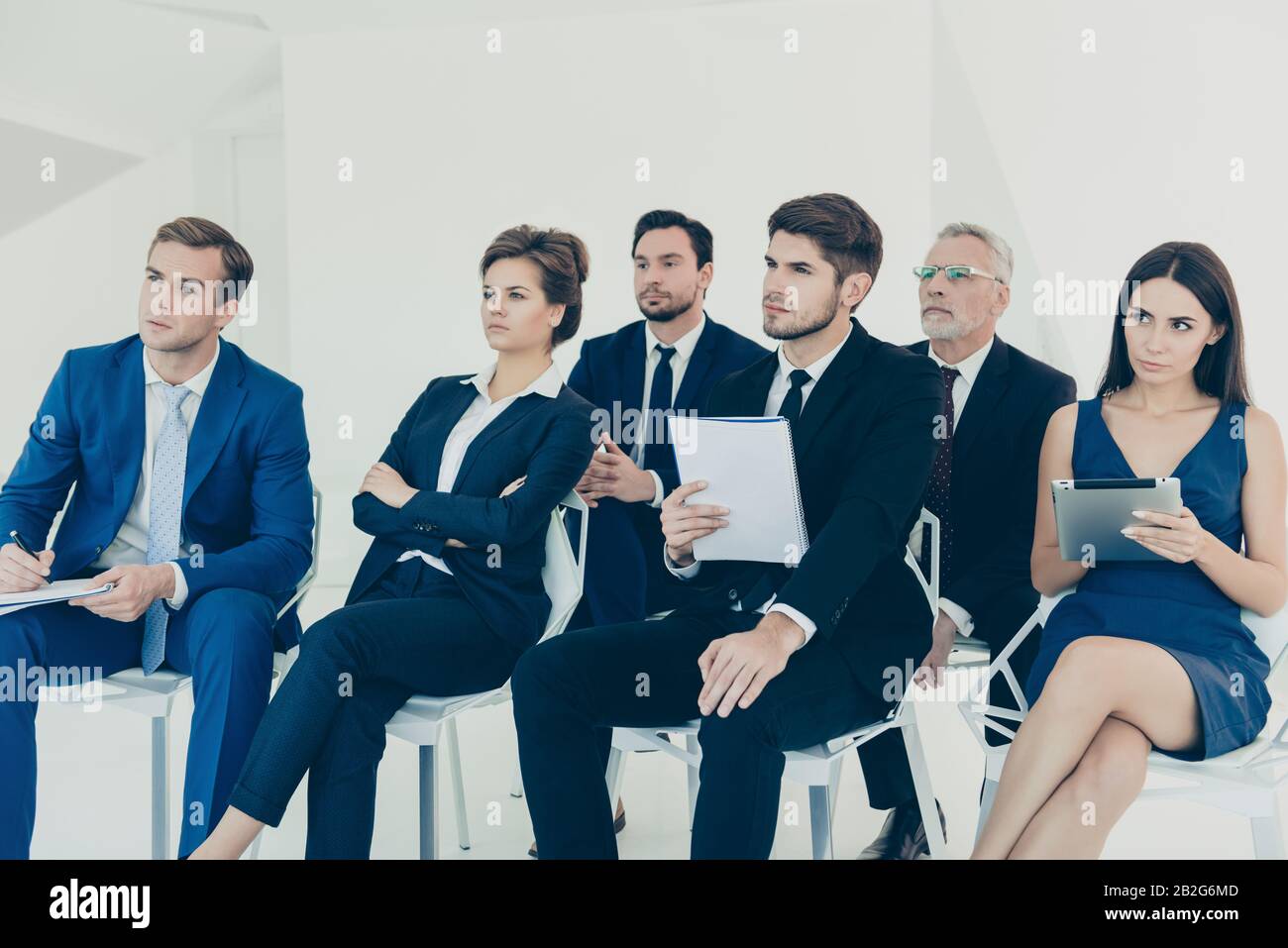 Confident young managers making notes during lecture Stock Photo