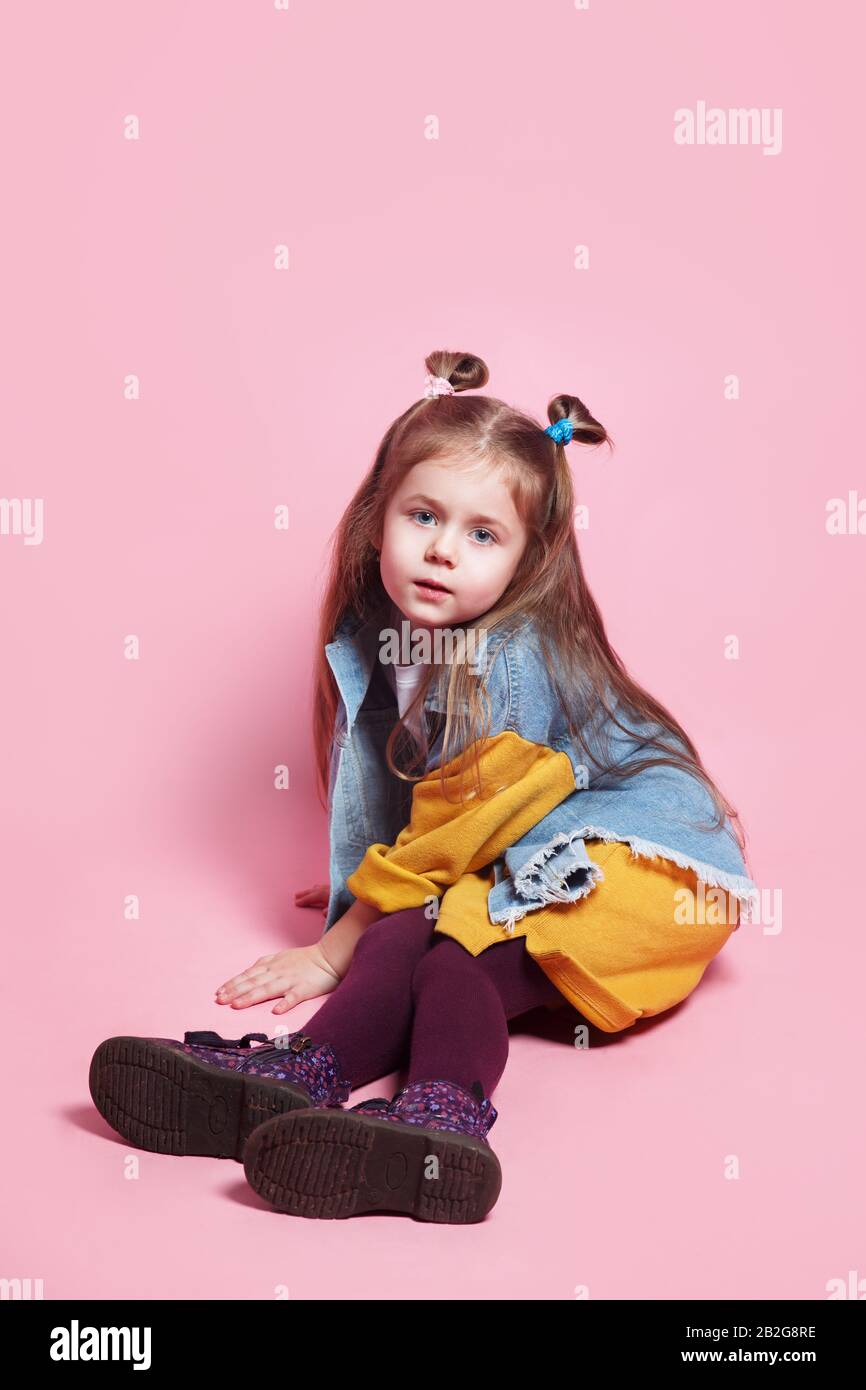 Stylish baby girl 4-5 year old wearing denim clothes posing on pink ...