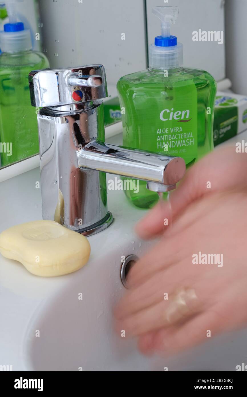 Man washing hands in bathroom with soap and water. Stock Photo