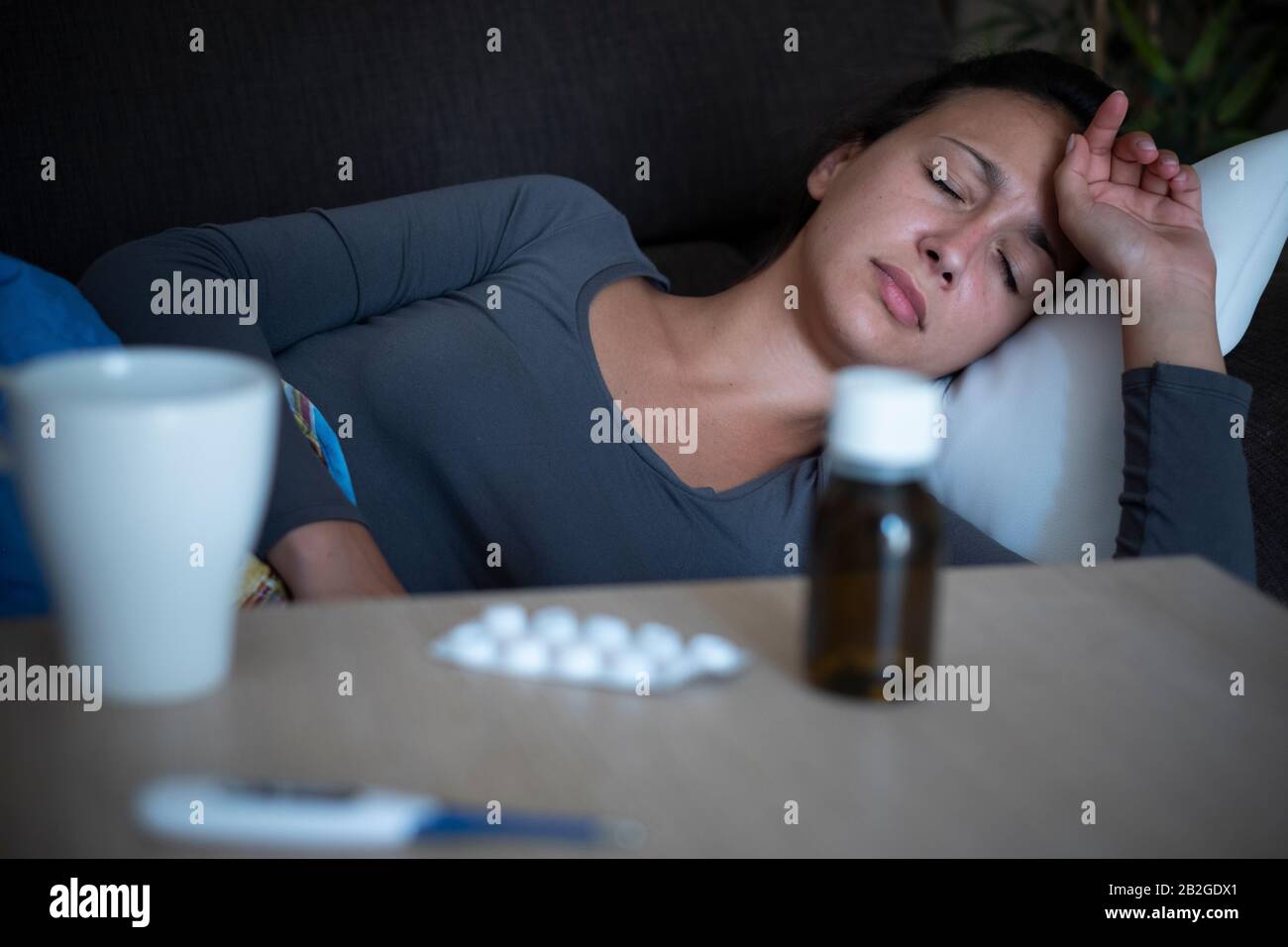 Woman lying on the sofa at home suffering headache Stock Photo Alamy