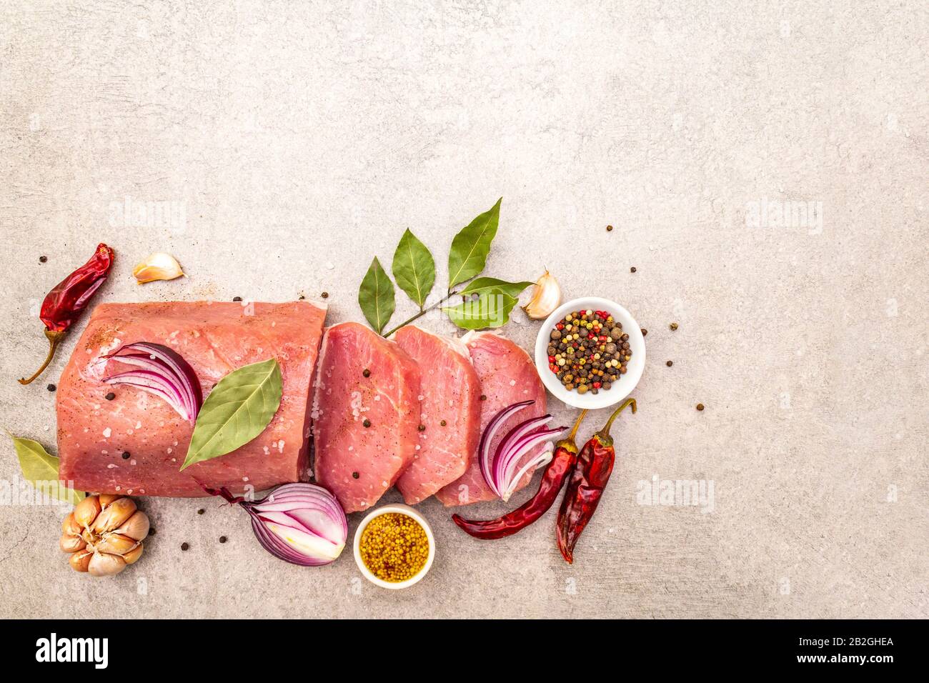 Raw pork tenderloin with vegetables and spices. Cooking meat background