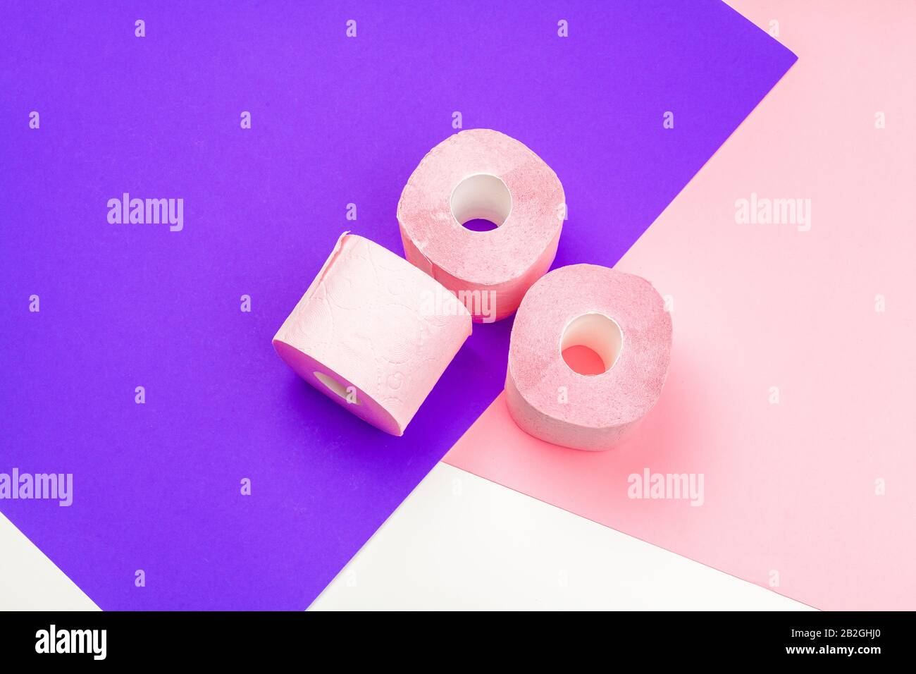 Pastel pink toilet paper on bright color block background Stock Photo