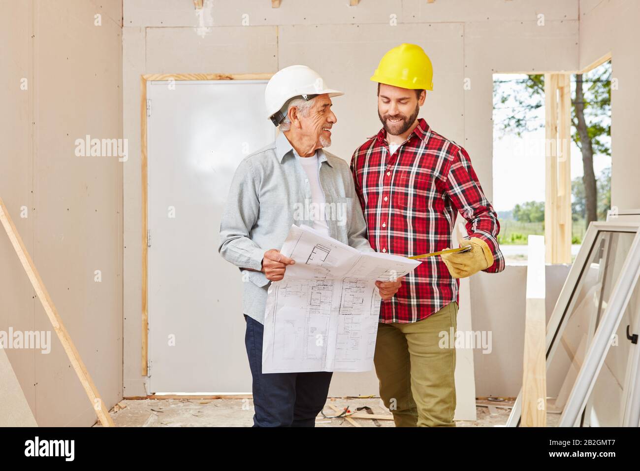 Architect and craftsman talk about blueprint in a house Stock Photo - Alamy